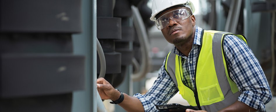 Worker looking at something, wearing hard hat, eyewear and vest