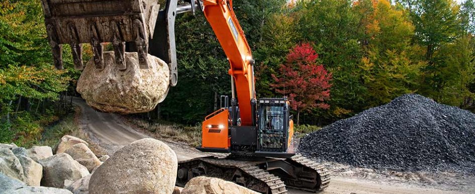 Construction equipment lifting heavy rock 
