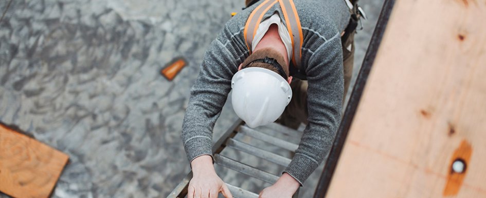 Person in hard hat climbing down ladder