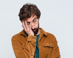 Man with hand on face in exasperation
