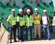 NETL project managers standing in front of the 135-inch earth pressure balancing tunnel boring machine used for tunneling at US-59