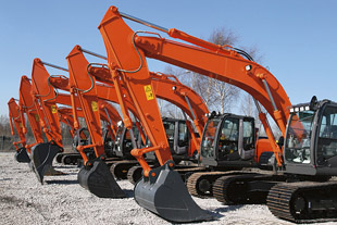 A line of excavators at a rental lot