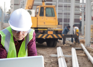 Working on a laptop at a jobsite