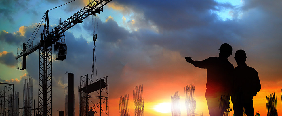Construction workers standing in field with power equipment