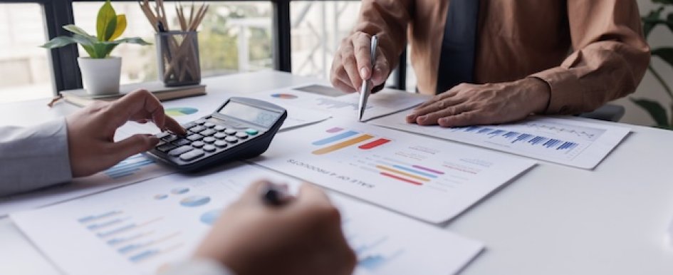 People reviewing financial charts with calculator