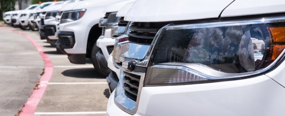 row of identical white trucks parked