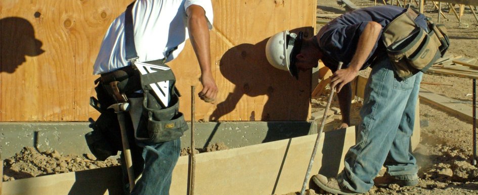 Construction workers pour concrete on the jobsite