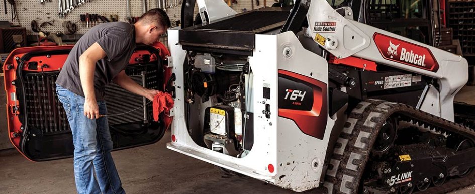 Worker in front of bobcat equipment