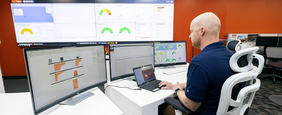 Image of man in an office viewing multiple computer screens