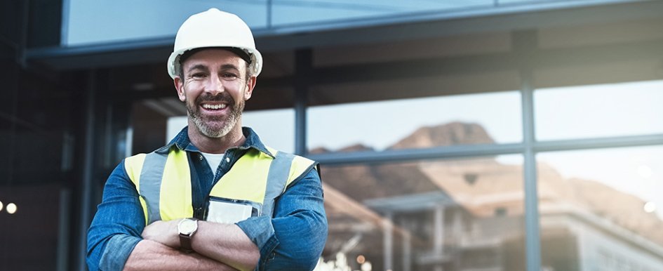 Man in hard hat and vest smiling 
