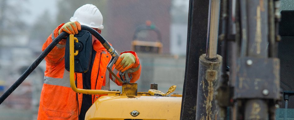 Construction worker using gas pump