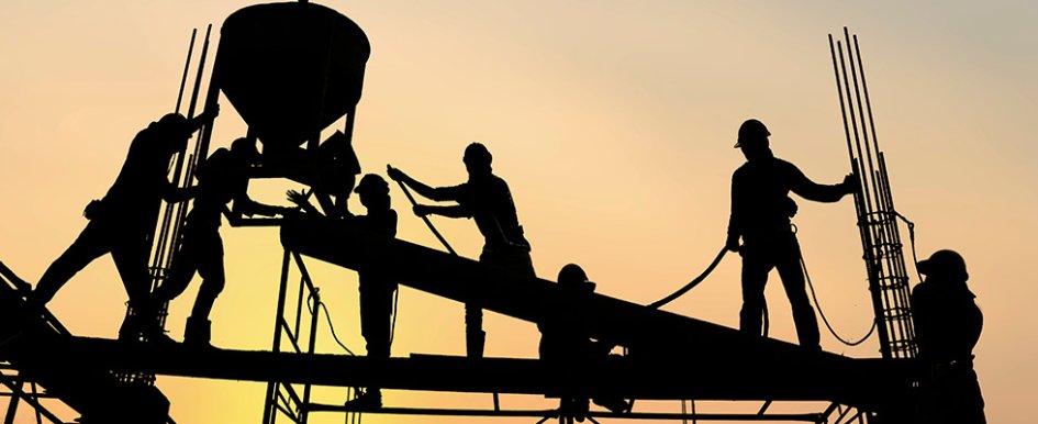 silhouettes of construction workers on scaffolding