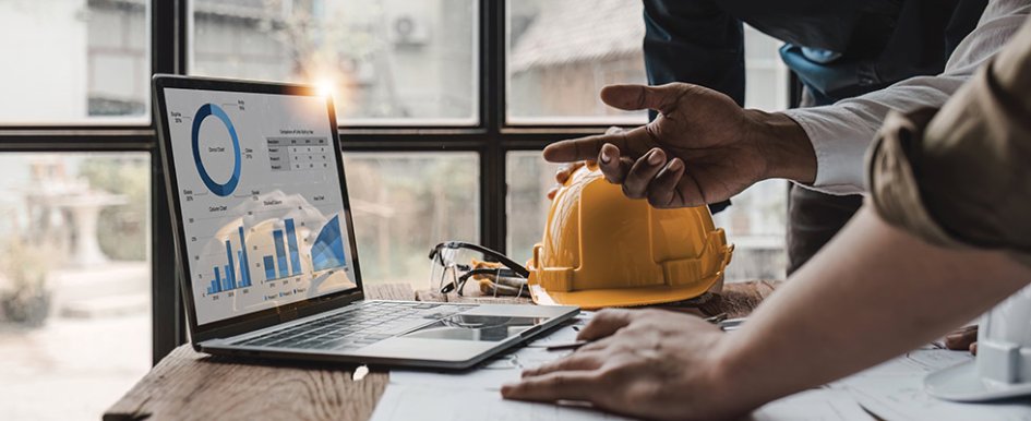 Construction workers point at computer