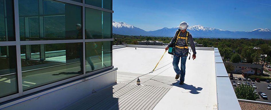 construction worker on roof wearing fall protection gear