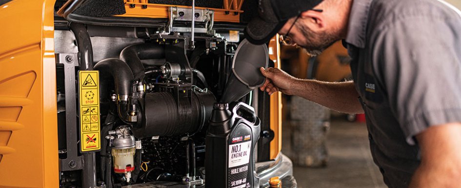 Man wearing CASE shirt and working on equipment