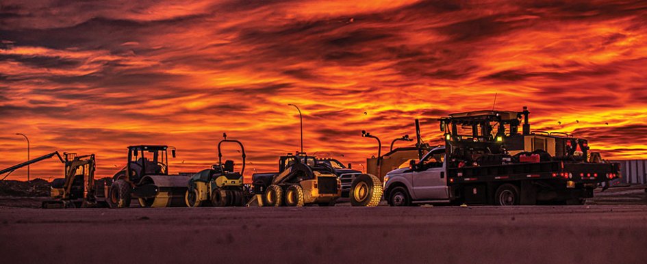 Construction fleet in front of vibrant background/Adobe Stock