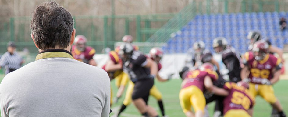 Football coach watching players