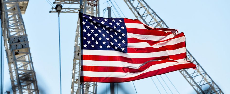 American flag waving over cranes 