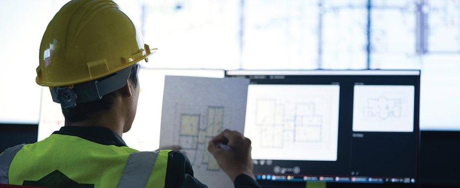 Construction worker in hard hat using technology