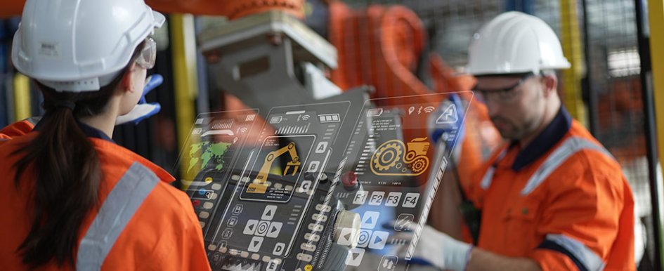 Two workers looking at hologram of technology with equipment icons