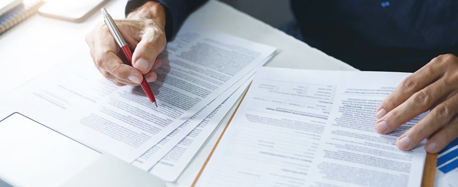 Person at desk signing paperwork 
