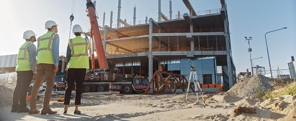 3 construction workers on a jobsite looking at machinery