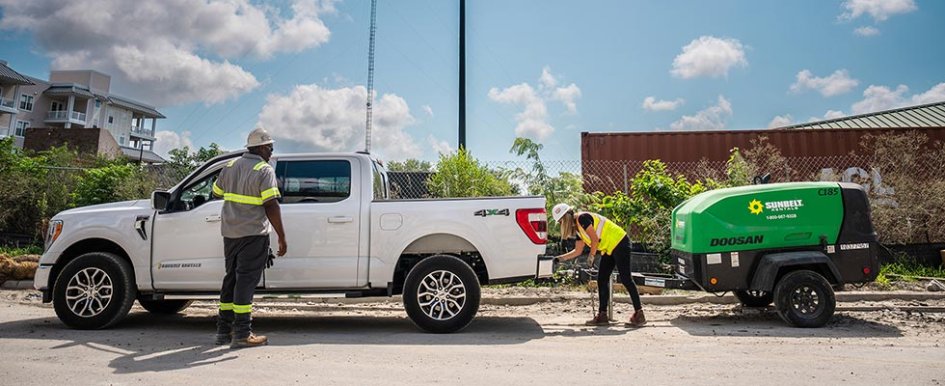 Two construction workers handling equipment from Sunbelt Rentals