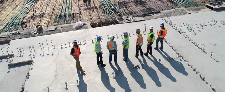 Workers in vests in a line on a jobsite