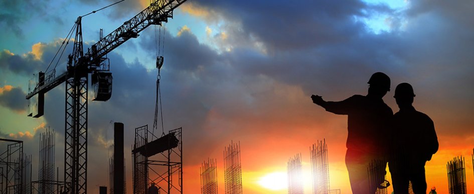 Construction workers standing in field with power equipment