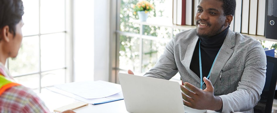 Two workers meeting across an office desk