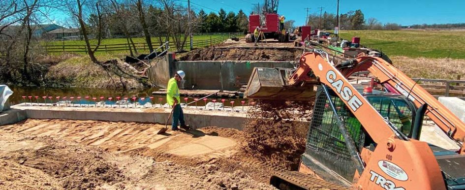 A construction site with heavy machinery and construction workers wearing bright safety colors