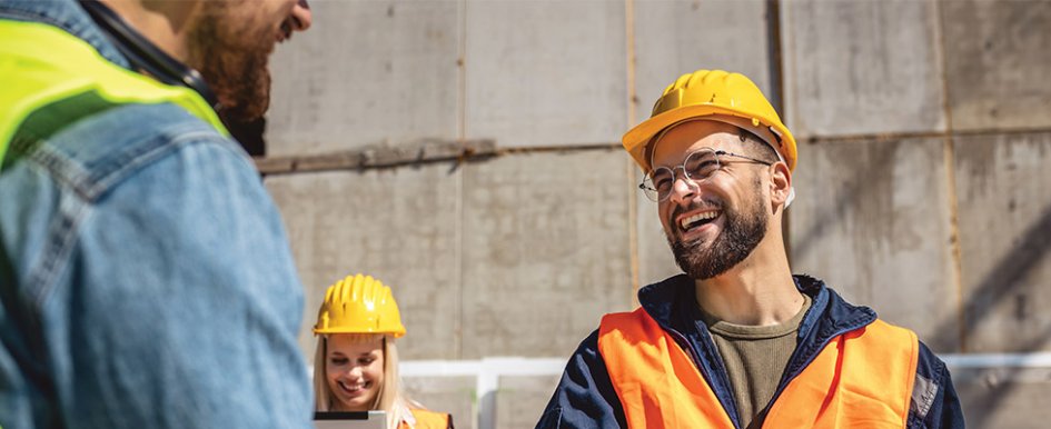 people in hard hats and vest smiling/Adobe Stock