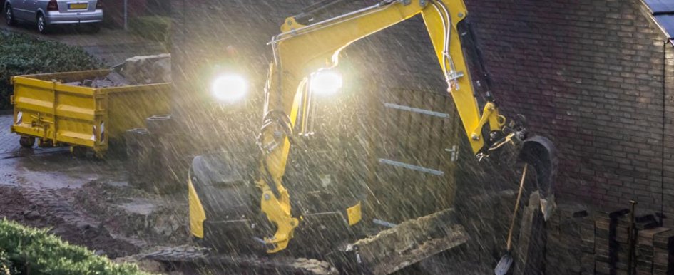 A yellow excavator in the rain