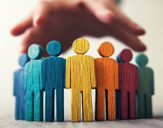 Colorful wooden figures under protective hand