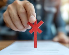 Hand placing red asterisk on document