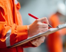 worker checking off list on notepad 