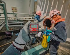 Worker monitoring gas levels in confined space