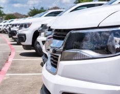 row of identical white trucks parked