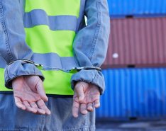 Construction worker in handcuffs to indicate employee theft 