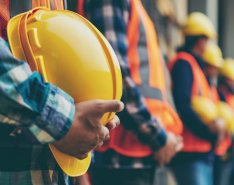 line of construction workers holding hard hats