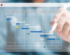 Hand with stylus touching tech schedule 