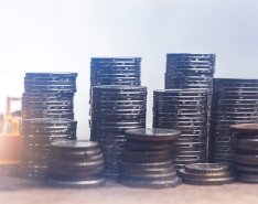 toy construction equipment approaching stacks of coins 