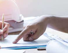 Two people looking at papers with hardhat in background