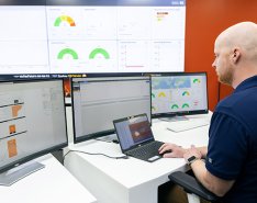 Image of man in an office viewing multiple computer screens