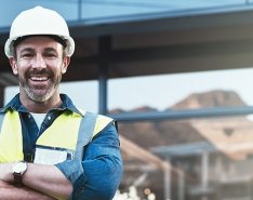 Man in hard hat and vest smiling 