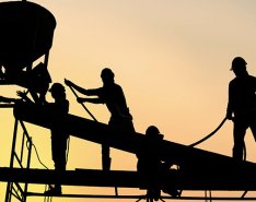 silhouettes of construction workers on scaffolding