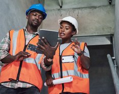 two construction workers looking at tablet and discussing
