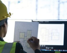 Construction worker in hard hat using technology