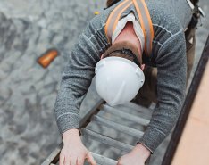 Person in hard hat climbing down ladder