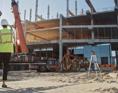 3 construction workers on a jobsite looking at machinery